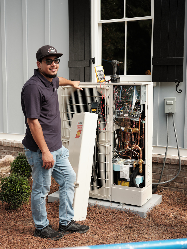HVAC technician standing with outdoor unit